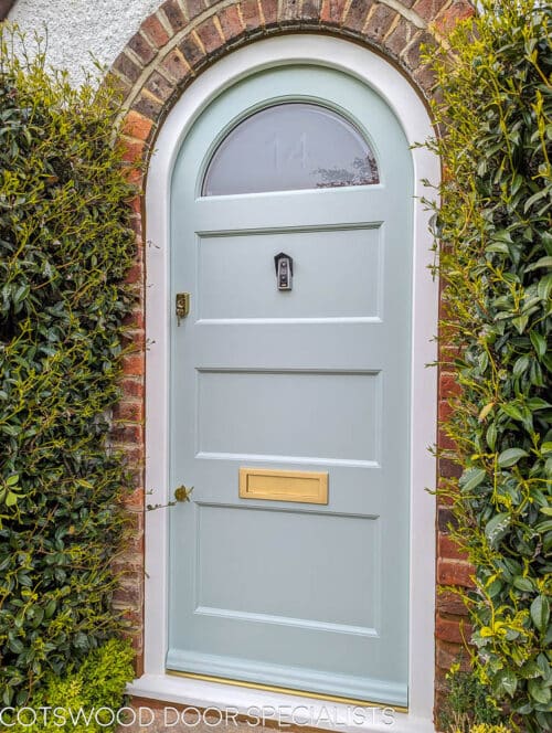 Arched 1920's front door and new frame fitted into a London home. Door and frame are both made of Accoya wood and painted in Teknos paint. The door has a sandblasted glass panel with a clear line and number detail in relief. Brass door furniture fitted. The arched frame matches the brickwork and is a true semi circle. Door made to closely match orginal simple 1920s doors locally