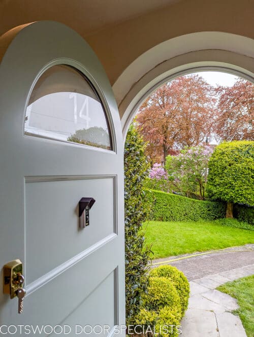 Arched 1920's front door and new frame fitted into a London home. Door and frame are both made of Accoya wood and painted in Teknos paint. The door has a sandblasted glass panel with a clear line and number detail in relief. Brass door furniture fitted. The arched frame matches the brickwork and is a true semi circle. Door made to closely match orginal simple 1920s doors locally