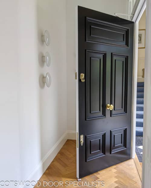 Georgian front firedoor. Large black Georgian style front door and sidelight door frame. Fire rated (fd30) door with fire rated glass and surround. Door frame is made to replicate the original door mouldings. Door has high secuirty banham locks in brass. Door installation blends seamlessly with original architrave features