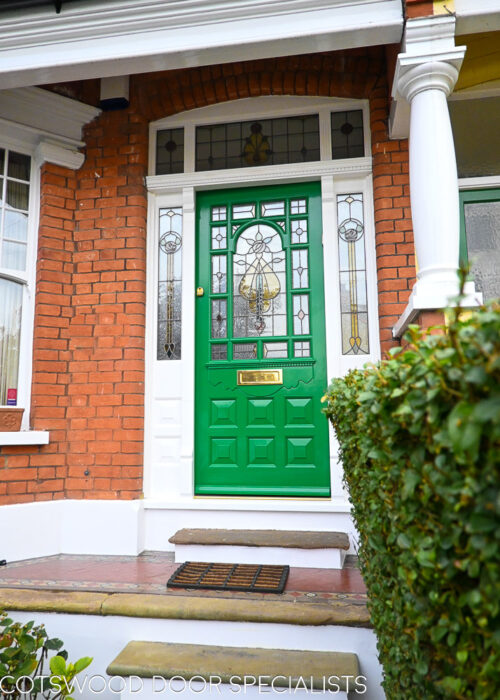 ornamental Edwardian front door with stained glass. A decorative 17 light Edwardian front door with decorative features such as a shelf and dentil block and an apron of which the letterplate is fixed too. The frame is a large frame with sidelights and glazing above the door. The door frame is very ornamental with pilasters (detailed moulding forming columns each side of the door) supporting a decorative transom with detailed mouldings and a dentil block. The stained glass is a art nouveau design featuring roses. door and frame are a replica of the orignal Edwardian joinery. Handmade in Accoya wood and fitted with multipoint locking