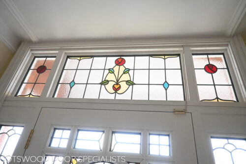 ornamental Edwardian front door with stained glass. A decorative 17 light Edwardian front door with decorative features such as a shelf and dentil block and an apron of which the letterplate is fixed too. The frame is a large frame with sidelights and glazing above the door. The door frame is very ornamental with pilasters (detailed moulding forming columns each side of the door) supporting a decorative transom with detailed mouldings and a dentil block. The stained glass is a art nouveau design featuring roses. door and frame are a replica of the orignal Edwardian joinery. Handmade in Accoya wood and fitted with multipoint locking. Internal picture of stained glass